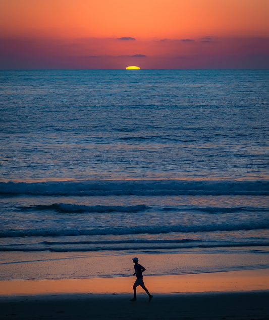 Person running on beach at sunset — active lifestyle and joint wellness